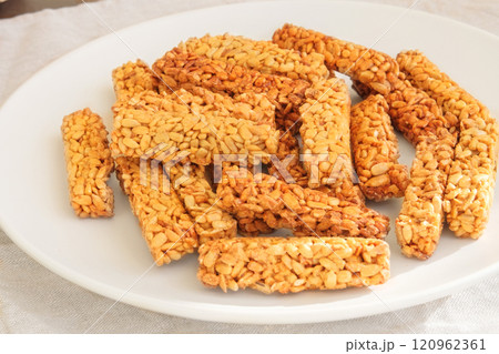 Gozinaki in a ceramic plate. Sweet granola in plate for holiday. Homemade seed sunflower candies. Gozinaki in a ceramic plate. Sweet granola in plate for holiday. Homemade seed sunflower candies. 120962361