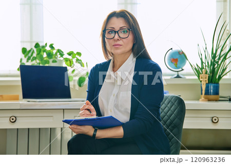 Portrait of woman mental specialist psychologist with clipboard folder on chair 120963236