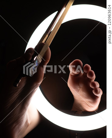 female legs with a violin bow in close-up in a round lamp. the concept of playing the violin .foot fetishism 120963614