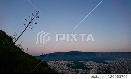 Athens, Greece - 30.3.2018: Aerial view of the urban skyline of modern Athens with the hillside in sight and the moon over the mountain range at the horizon in spring, view from Lykavittos Hill 120963705