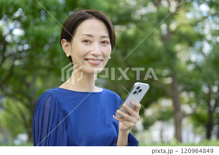 公園でスマホを持つ女性 カメラ目線 公園でスマホを持つ女性 カメラ目線 120964849