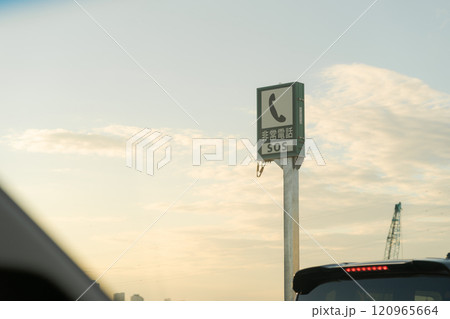 高速道路の非常電話の看板と夕焼け 120965664