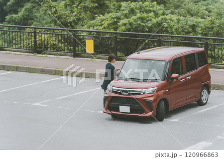 駐車場の枠からはみ出して駐車する自動車 120966863