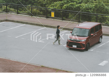 駐車場の車に戻る女性 120966866