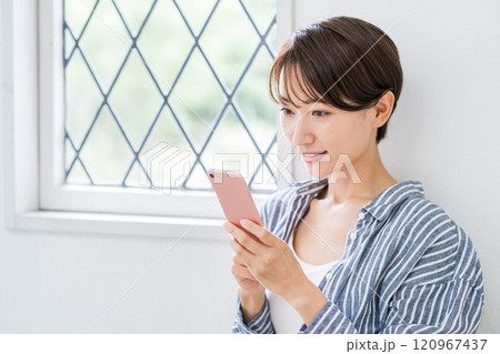 スマホを操作するミドル女性。 120967437