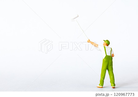 A miniature figure of a painter using a long roller brush to paint on a white background A miniature figure of a painter using a long roller brush to paint on a white background 120967773