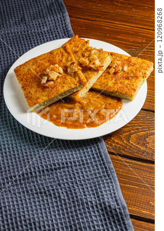 Baked potato pancakes with mushroom sauce on a gray towel and wooden table Baked potato pancakes with mushroom sauce on a gray towel and wooden table 120968268