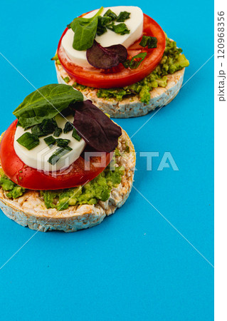 Rice cakes with mozzarella avocado spinach onion on a blue background Rice cakes with mozzarella avocado spinach onion on a blue background 120968356