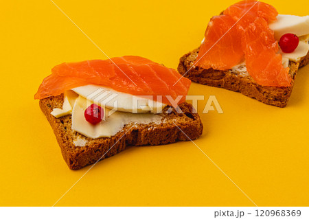 Salmon pieces on fresh toast spread with butter and a slice of mozzarella Salmon pieces on fresh toast spread with butter and a slice of mozzarella 120968369
