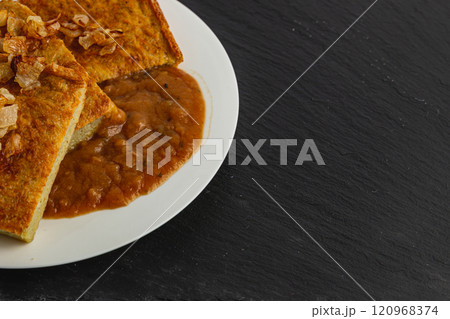 Oven-baked potato pancakes with mushroom sauce and onions on a stone board Oven-baked potato pancakes with mushroom sauce and onions on a stone board 120968374