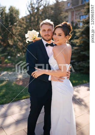 bride and groom cuddling in the autumn park on the territory of the hotel bride and groom cuddling in the autumn park on the territory of the hotel 120968597
