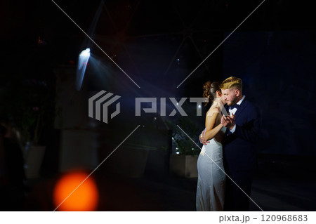 The bride and groom dance the first dance at the wedding banquet. 120968683