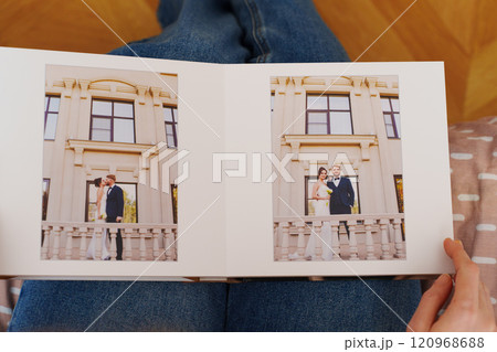 Female hands flipping through a photo book with wedding photos Female hands flipping through a photo book with wedding photos 120968688
