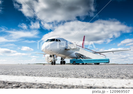 White passenger aircraft with stair car at the airport apron White passenger aircraft with stair car at the airport apron 120969507