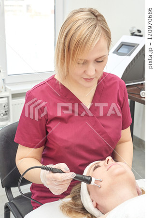 Female caucasian adult aesthetician performing facial treatment on female client Female caucasian adult aesthetician performing facial treatment on female client 120970686