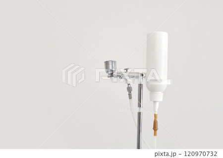 Airbrush makeup system with white bottle and metal components on stand Airbrush makeup system with white bottle and metal components on stand 120970732