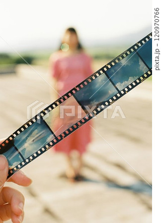 空のリバーサルフィルム越しのピンクのドレスの女性 120970766