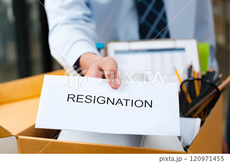 Employee handing in a resignation letter during a workplace transition. 120971455