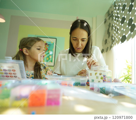 Teacher in workshop teched two girls how to assemble a thermo mosaic  120971800