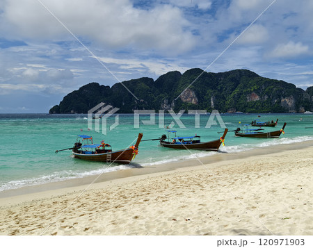 A serene and beautiful tropical beach paradise featuring traditional boats 120971903