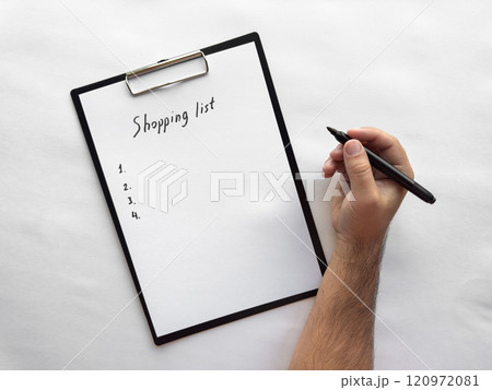 Handwriting a minimalist shopping list on clipboard 120972081
