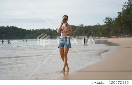 A young woman enjoying a beautiful day at the beach  120972136