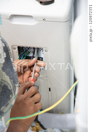 Technician  install  air conditioner outdoor unit 120972351