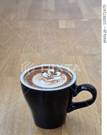 Artistic Latte in Black Mug on Wooden Table Artistic Latte in Black Mug on Wooden Table 120972470