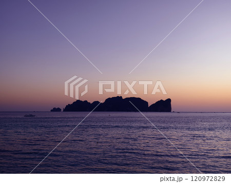 A stunning sunset is casting vibrant hues of color over a tranquil ocean A stunning sunset is casting vibrant hues of color over a tranquil ocean 120972829