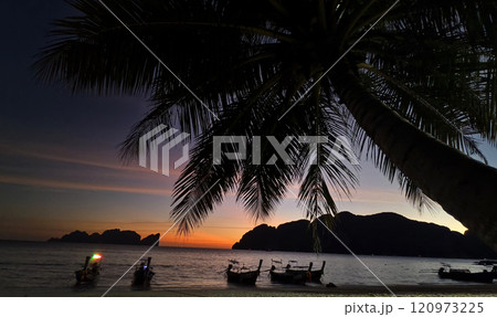 A stunning sunset is casting vibrant hues of color over a tranquil ocean 120973225