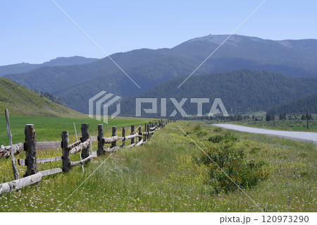 An old wooden fence in a meadow at the foot of the mountains in the Altai Mountains in summer An old wooden fence in a meadow at the foot of the mountains in the Altai Mountains in summer 120973290