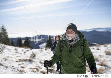 Winter hike for an elderly man in snowy mountains. Active seniors enjoying nature. Winter hike for an elderly man in snowy mountains. Active seniors enjoying nature. 120973556