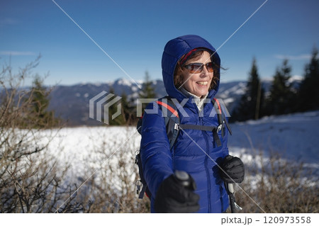 Elderly woman during winter hike in snowy mountains. Active female senior enjoying nature. Elderly woman during winter hike in snowy mountains. Active female senior enjoying nature. 120973558
