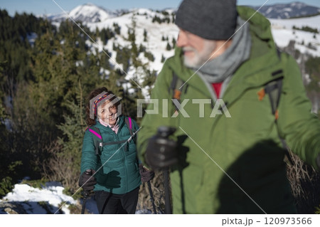 Elderly woman during winter hike in snowy mountains. Active female seniors enjoying nature. 120973566