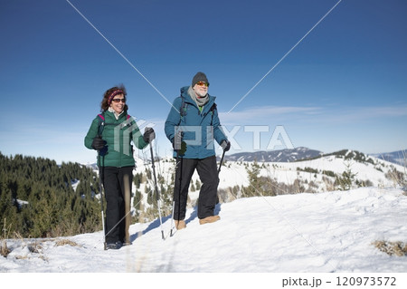 Active seniors enjoying winter nature. Romantic winter hike for an elderly couple in snowy mountains. Active seniors enjoying winter nature. Romantic winter hike for an elderly couple in snowy mountains. 120973572