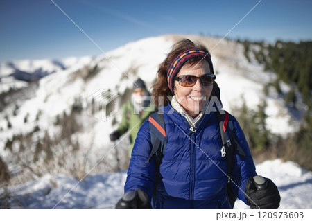 Winter hike for an elderly man in snowy mountains. Active senior enjoying nature. 120973603