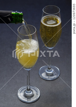 よく冷えたシャンパン（スパークリングワイン）をフルートグラスに注ぐ 120973693
