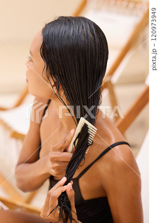 Long Hair Woman Combing Wet Hair in Relaxing Spa Environment 120973949