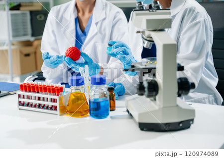 scientists in lab coats conducting research, handling glassware, and working with chemicals scientists in lab coats conducting research, handling glassware, and working with chemicals 120974089
