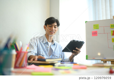 Young adult man collaborating with his team on app design and UI UX development in the office Young adult man collaborating with his team on app design and UI UX development in the office 120976059