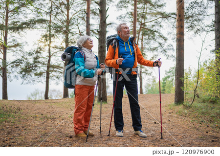 Hiking tourism adventure. Senior couple man woman enjoying outdoor recreation hiking in forest. Happy old people backpackers hikers enjoy walking hike trekking tourism active vacation beauty of nature Hiking tourism adventure. Senior couple man woman enjoying outdoor recreation hiking in forest. Happy old people backpackers hikers enjoy walking hike trekking tourism active vacation beauty of nature 120976900