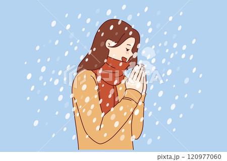 Woman enjoys winter weather, stands under falling snow flakes in sweater and scarf 120977060