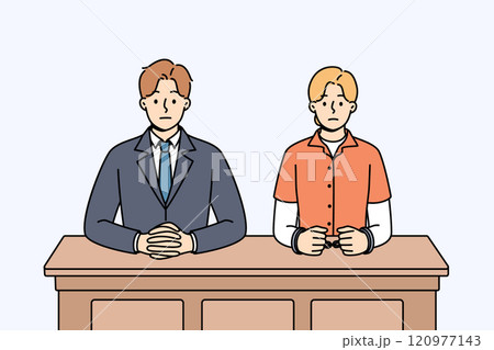 Man lawyer and woman defendant in handcuffs sit at table awaiting verdict from judge 120977143