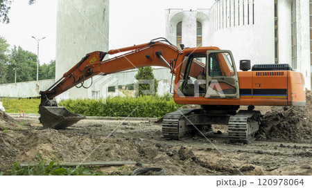 orange construction excavator near the construction site 120978064