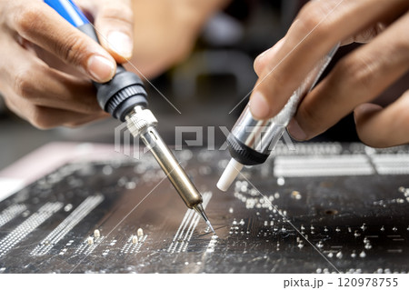Man technician soldering a circuit board Man technician soldering a circuit board 120978755