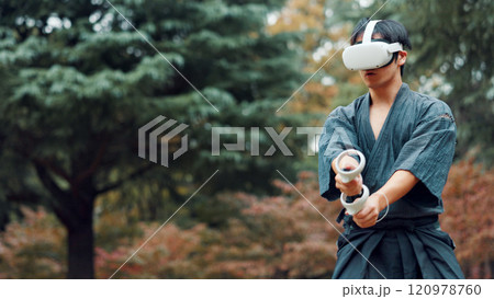 Virtual reality, controller and Asian man with technology for martial arts, Kendo practice and exercise. Culture, Japan and person with shinai, VR goggles and metaverse for skill, fight and training 120978760