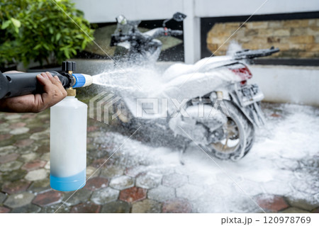 Professional worker hand washing the motorcycle with cleaning foam Professional worker hand washing the motorcycle with cleaning foam 120978769