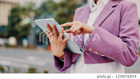 Online, hands and person with tablet in street for social networking, reading ebook and travel location search. Japan, scroll or technology for internet research, web information or streaming service 120978854