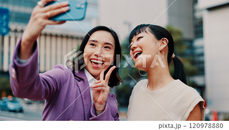Business women, selfie and friends in city with smile for peace sign, partner or excited for post on web. People, partnership and photography with memory, happy and icon with profile picture in Japan 120978880
