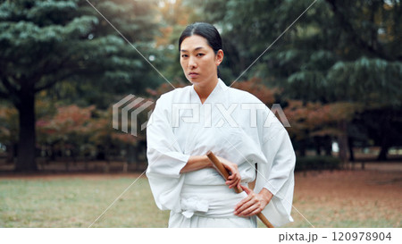 Portrait, Japanese woman and outdoor for martial arts as athlete for training, exercise or stance. Female person, culture and ready for challenge, combat or practice for defence technique for bojutsu Portrait, Japanese woman and outdoor for martial arts as athlete for training, exercise or stance. Female person, culture and ready for challenge, combat or practice for defence technique for bojutsu 120978904